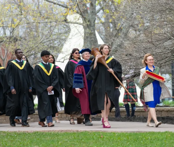Marshal, Sue Dawson; Macebearer, Shanelle Berthier, Faculty of Science; and Eagle Feather Bearer, Erin Reid, assistant professor, Faculty of Indigenous Knowledge, Education, Research, and Applied Studies, lead graduates in the Faculty of Science into the Chi-Wan Young Sports Centre for their Convocation ceremony on May 16. Marshal, Sue Dawson; Macebearer, Shanelle Berthier, Faculty of Science; and Eagle Feather Bearer, Erin Reid, assistant professor, Faculty of Indigenous Knowledge, Education, Research, and Applied Studies, lead graduates in the Faculty of Science into the Chi-Wan Young Sports Centre for their Convocation ceremony on May 16.