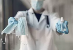 image of person holding mask, sanitizer