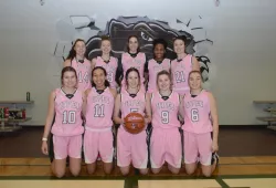 A posed image of ten female basketball players wearing pink jerseys