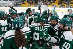 photo of women's hockey team hugging each other after win