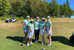 President Wendy Rodgers (centre) joins Office of the President team members (left to right): Heather Howatt, Jane Ngobia, Nicole Phillips, and Pam Trainor photo of five women wearing green shirts, standing on a golf course