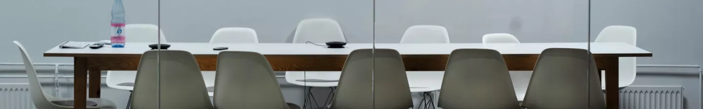 boardroom table with 12 white chairs