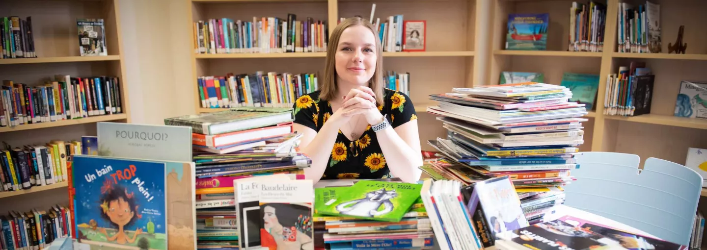 a female teacher surrounded by french books