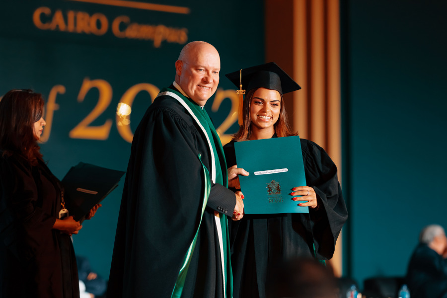 Graduate receiving degree from president on convocation stage