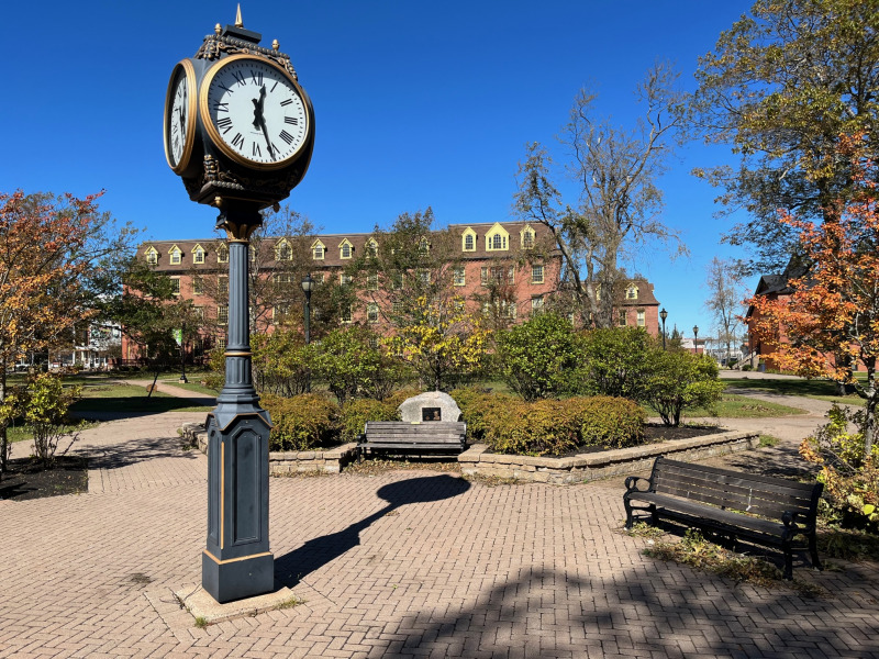 image of clock in campus plaza with blue sky 
