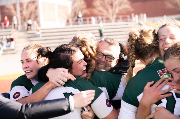 photo of women's rugby team hugging after win
