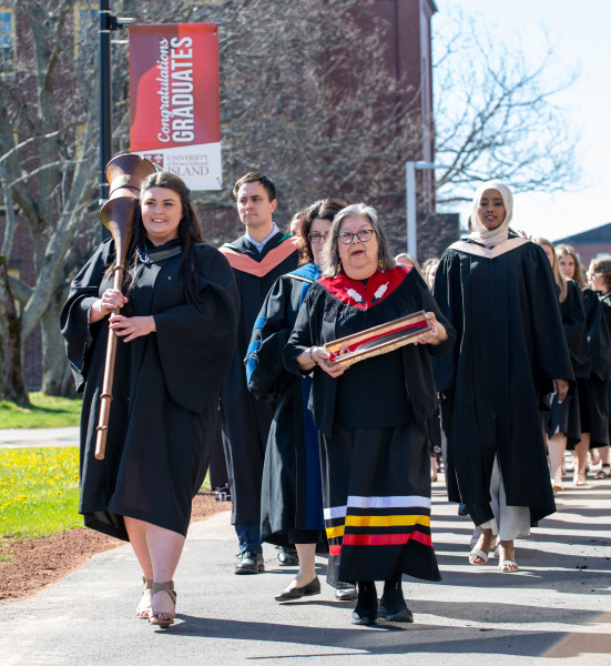 Macebearer Katherine Guarino and Eagle Feather Bearer Dr. Judy Clark, Elder in Residence at UPEI, lead graduates in the faculties of Nursing and Veterinary Medicine into the Chi-Wan Young Sports Centre for their Convocation ceremony on May 14.