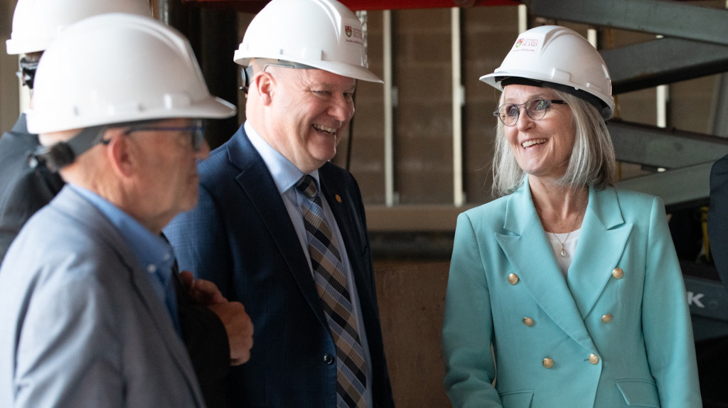 photo of three people wearing suits and hard hats