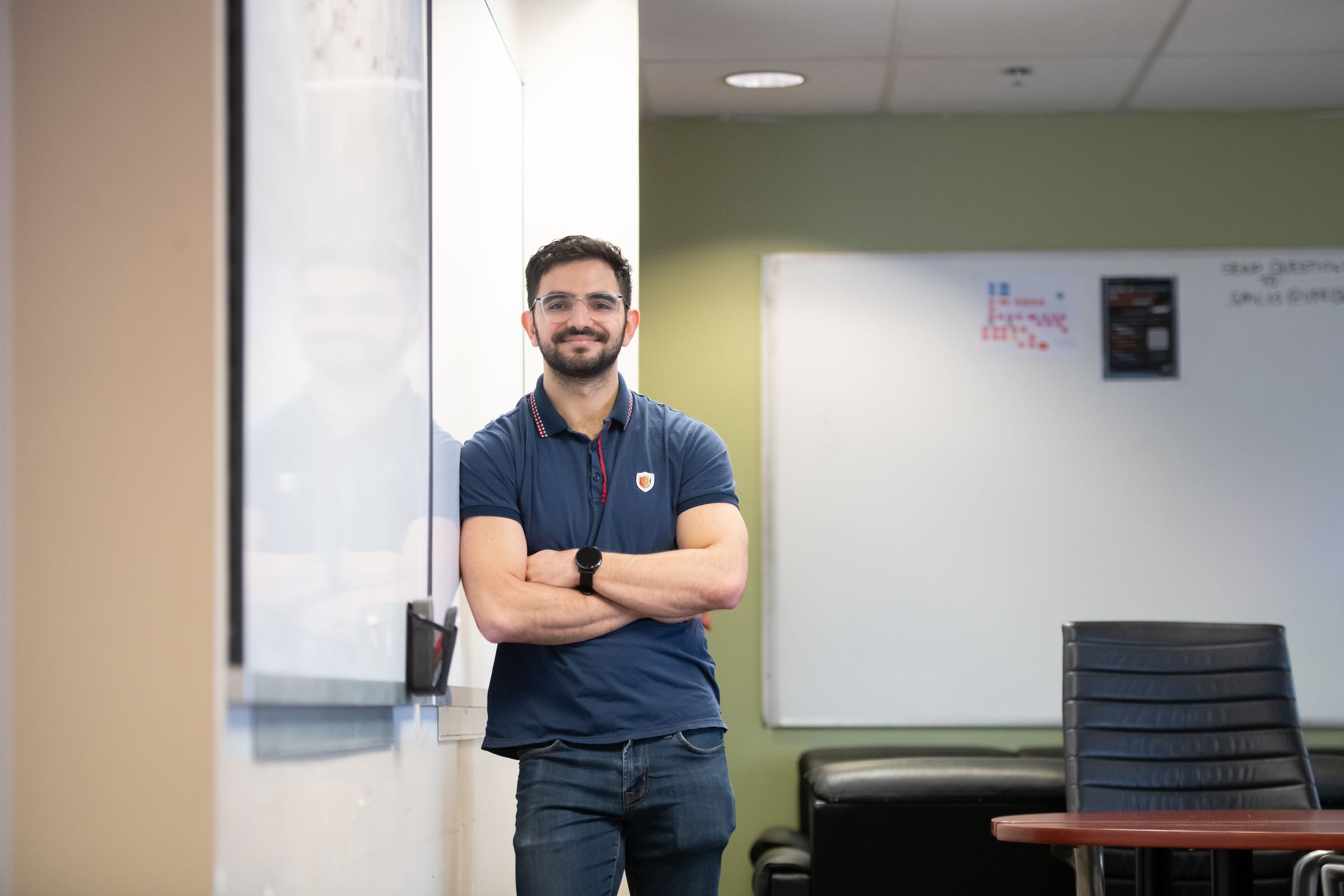 UPEI mathematics and economics student Samuel leaning up to a classroom whiteboard