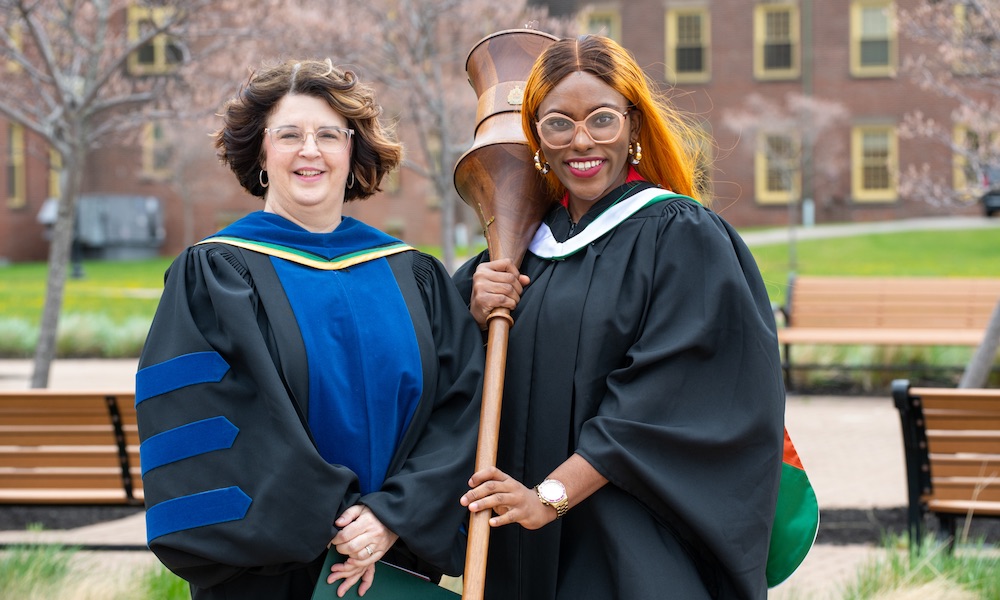 two women in academic gowns with the UPEI mace