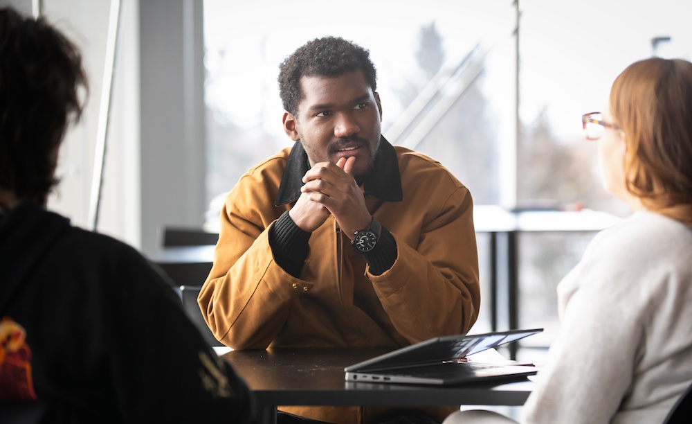 UPEI MBA-GL student Fahad speaking with two other students