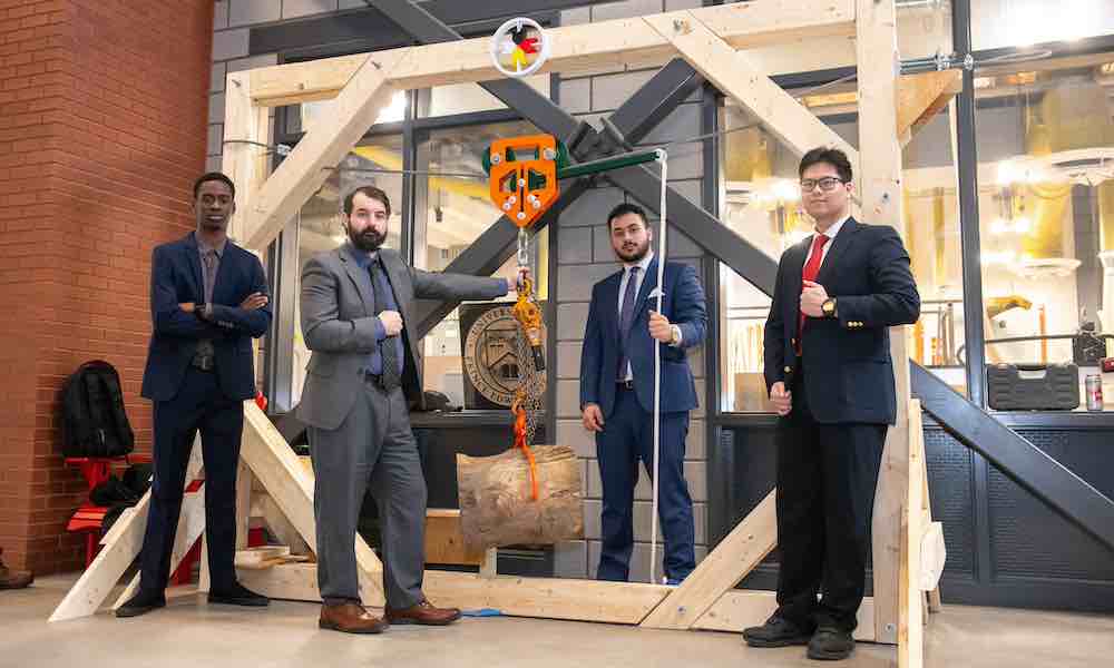 four UPEI engineering students with their second-year project prototype