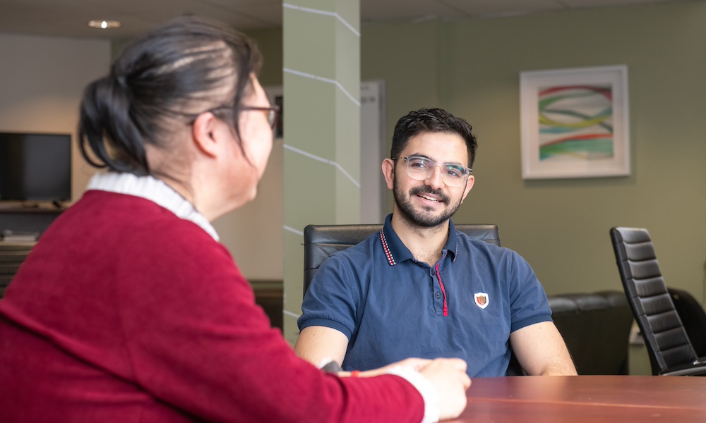 UPEI mathematics student Samuel talking to a colleague