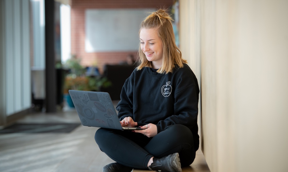 a UPEI education student working on a laptop computer