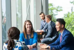 Students sit at a table talking