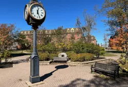 image of clock in campus plaza with blue sky 