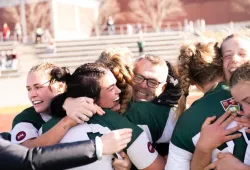 photo of women's rugby team hugging after win