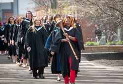 Macebearer Gloria Chimwe-Etu Wonodi leads graduates in the faculties of Arts, Education, and Graduate Studies into the Chi-Wan Young Sports Centre for their convocation ceremony on May 18.