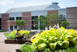 photo of student in front of modern brick building