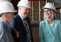 photo of three people wearing suits and hard hats