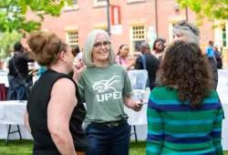 photo of woman speaking to others at an outdoor gathering