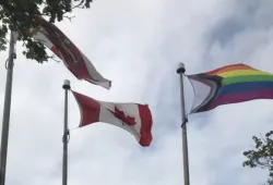 Photo of Progress Pride flag flying along side PEI and Canada flags