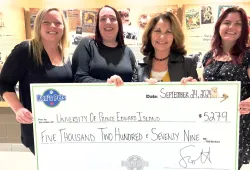 Ren's Pets associates present a cheque to Dr. Dominique Griffon