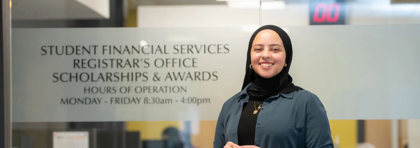 a person standing outside the UPEI Scholarships and Awards Office