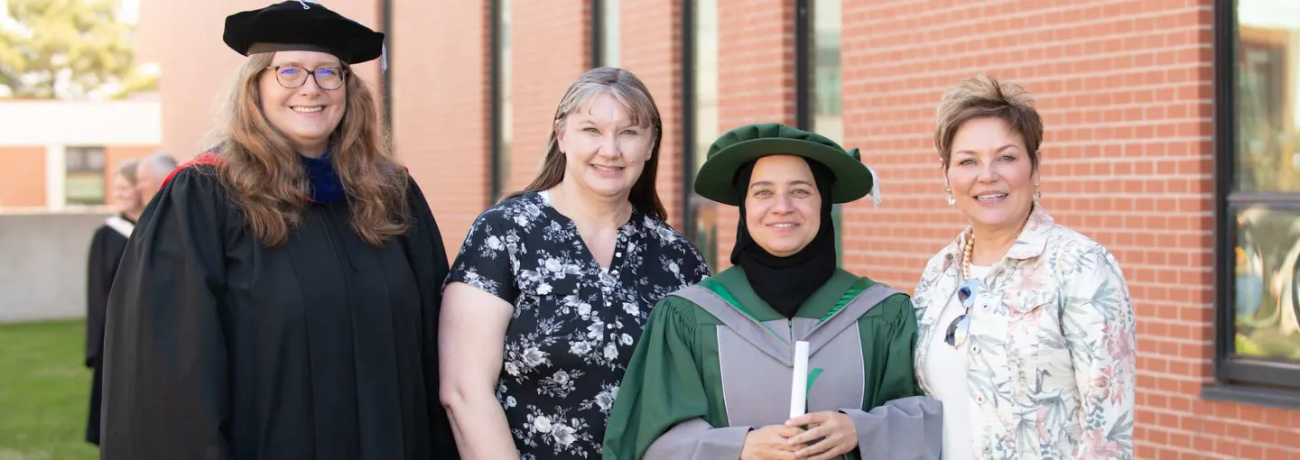 four people posing after UPEI convocation