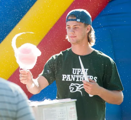 A man spins cotton candy at the campus carnival