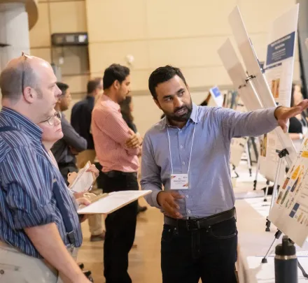 a student explaining a presentation to two people