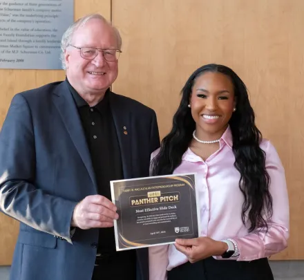 two smiling people holding an envelope 