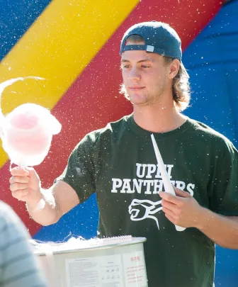 A man spins cotton candy at the campus carnival