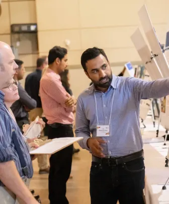 a student explaining a presentation to two people