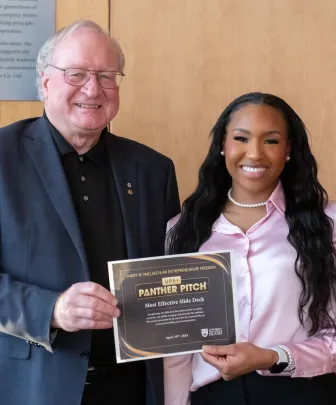 two smiling people holding an envelope 