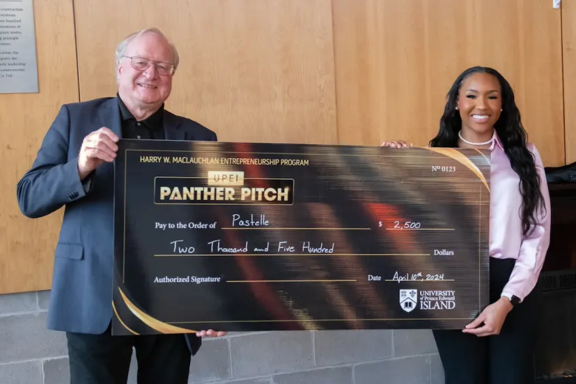 a student entrepreneur and a donor holding a large check