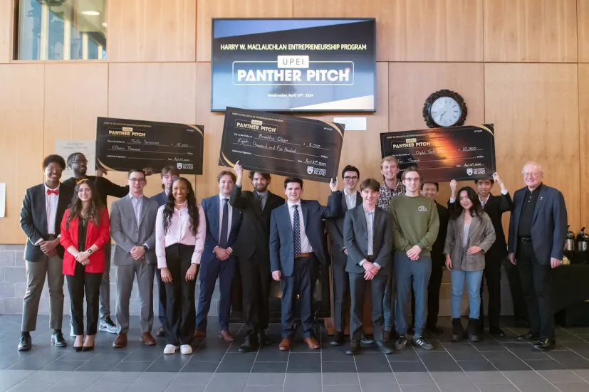 a group of student entrepreneurs holding large check