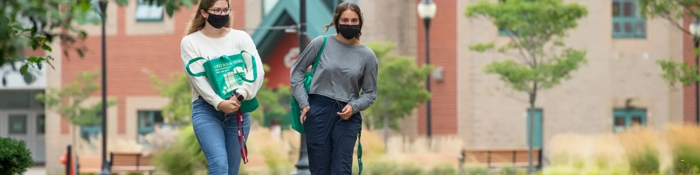 Students walk across campus in face masks 