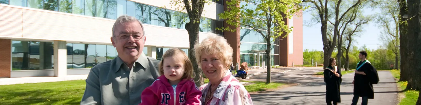 Donors stand with their granddaughter on campus