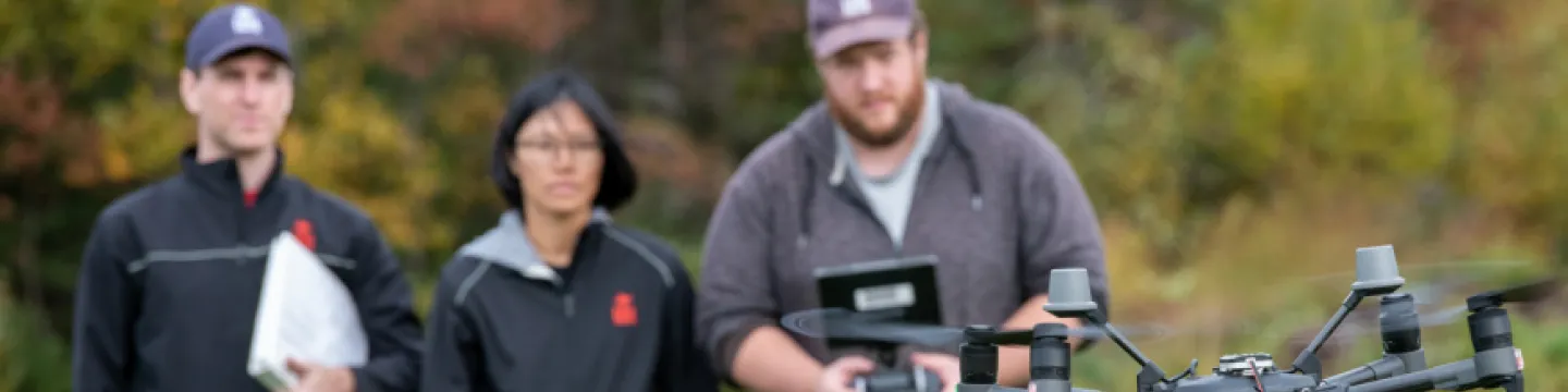 Researchers watch a drone take off