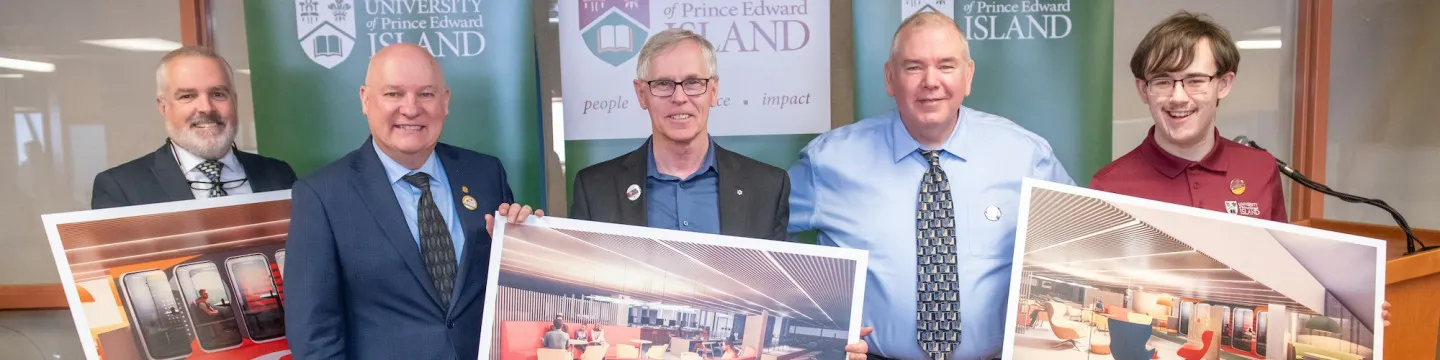 five people in the Robertson Library holding large prints of construction renderings