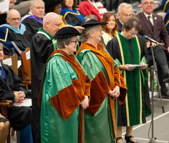 Photo of a man placing a hat on a woman at a convocation ceremony